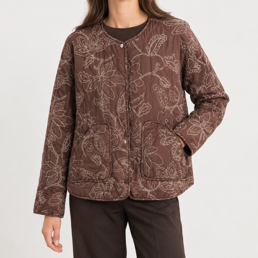 Front view showing round neckline, snap front placket, long sleeves and patch pockets, brown