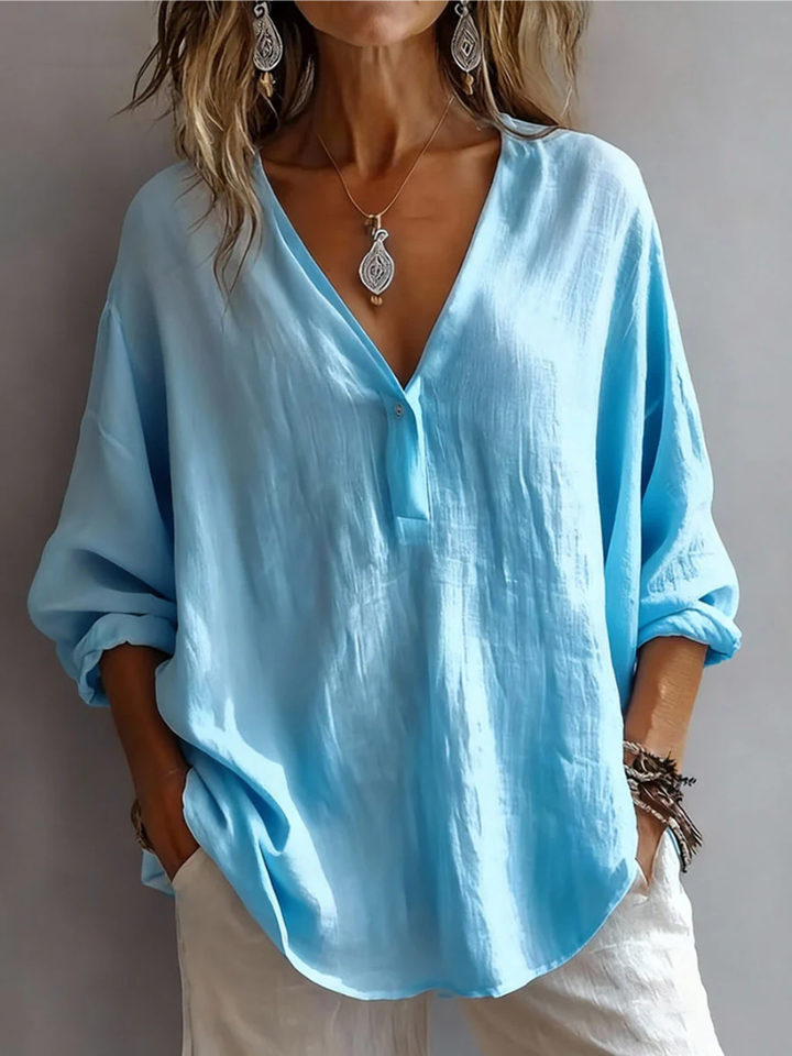 Front view showing deep v-neckline, button placket and long sleeves, blue