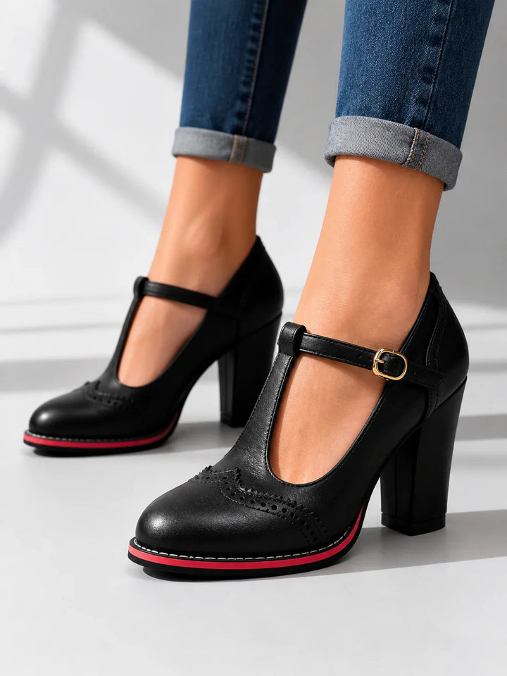 Side view showing t-bar strap, buckle, brogue toe and block heel, black