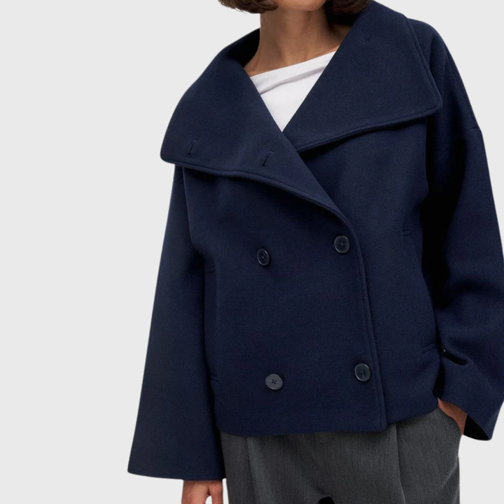 Side view showing wide lapels, double-breasted buttons and long sleeves, navy blue