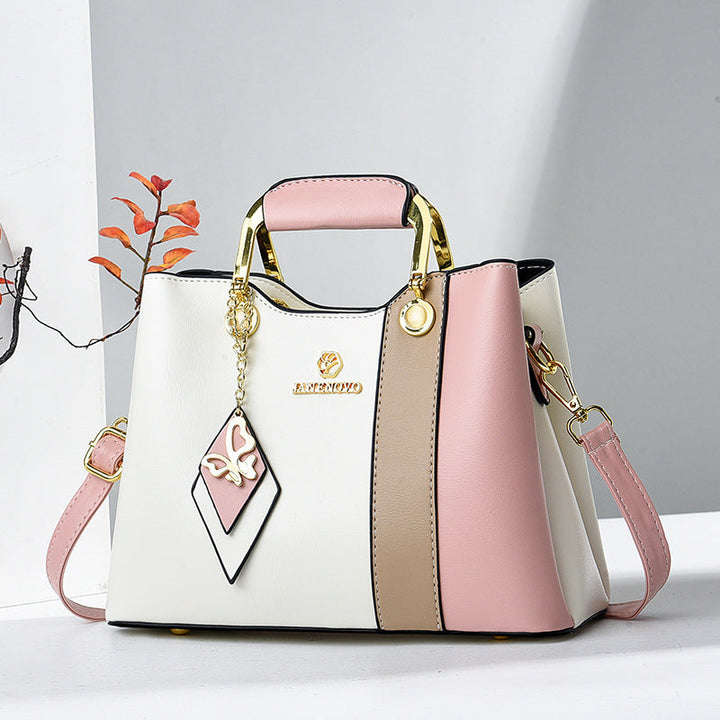 Front view showing top handle, butterfly charm and crossbody strap