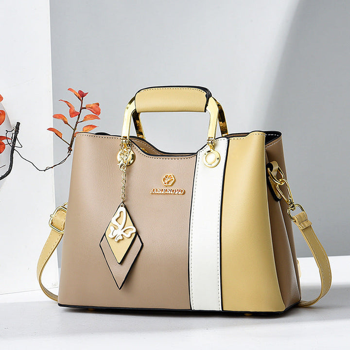 Front view showing top handle, butterfly charm and crossbody strap
