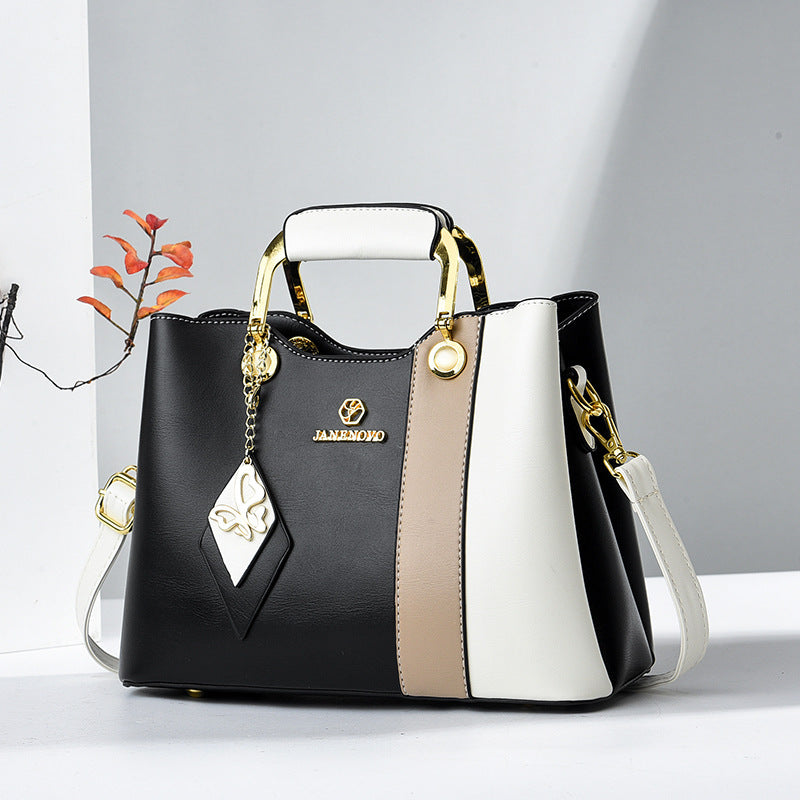 Front view showing top handle, butterfly charm and crossbody strap