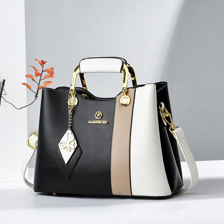 Front view showing top handle, butterfly charm and crossbody strap
