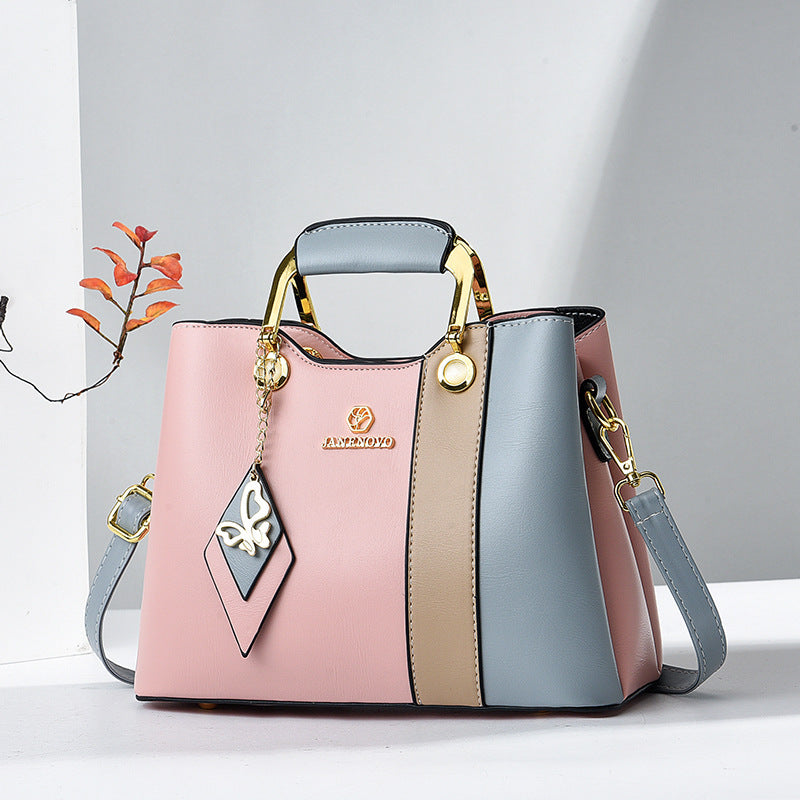 Front view showing top handle, butterfly charm and colour-block body