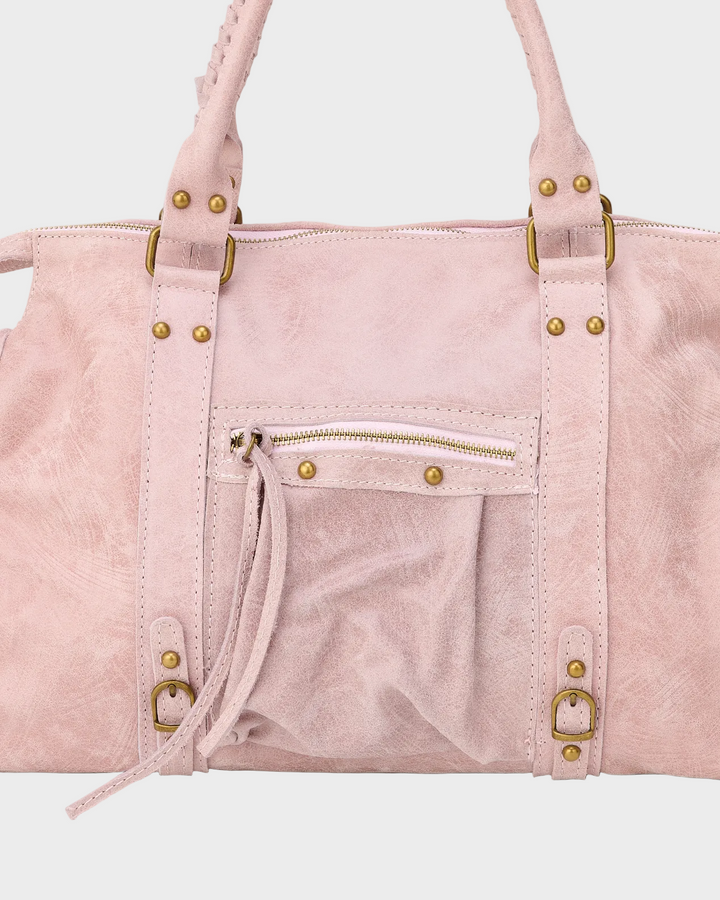 Detail view of front zip pocket, studs and buckles