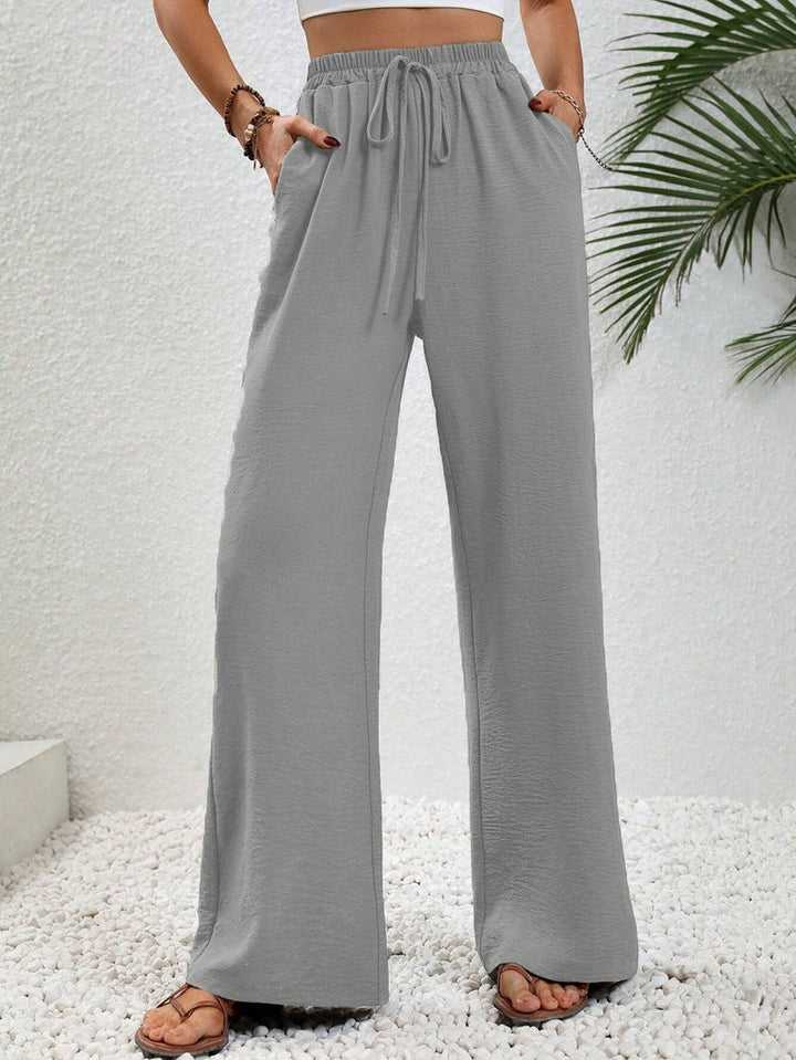 Front view of side pockets and gathered banded waist with drawstring tie, grey