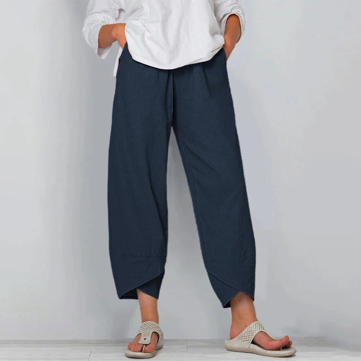 Front view of wide leg trousers with side pockets and overlapping panel hem, navy blue