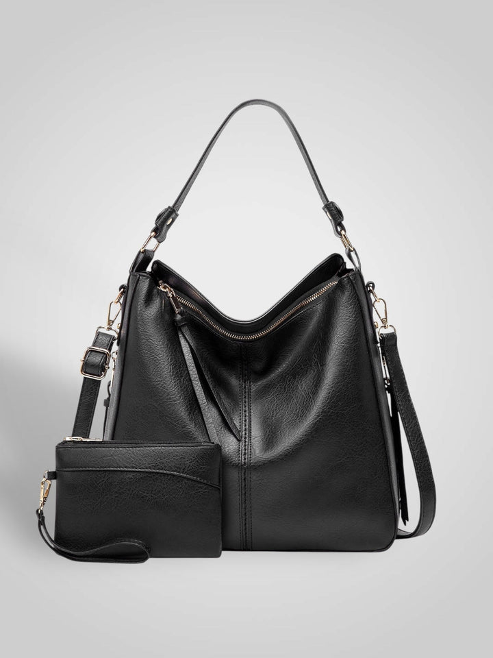 Front view showing top handle, crossbody strap, top zip closure and matching pouch, black