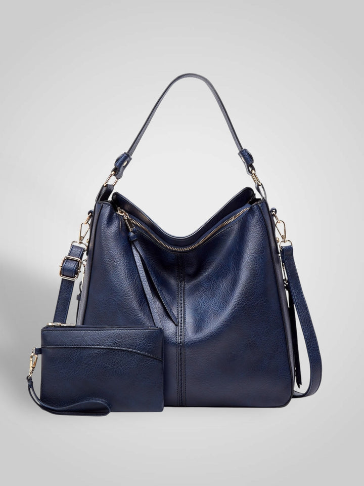 Front view showing top handle, crossbody strap, top zip closure and matching pouch, blue