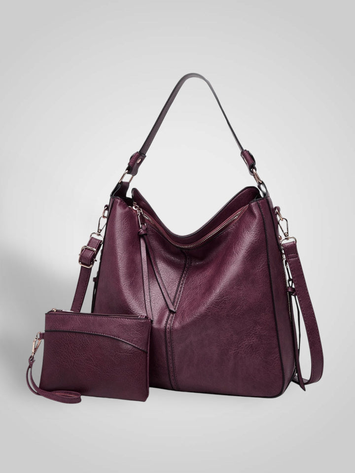 Front view showing top handle, crossbody strap, top zip closure and matching pouch, bordeaux