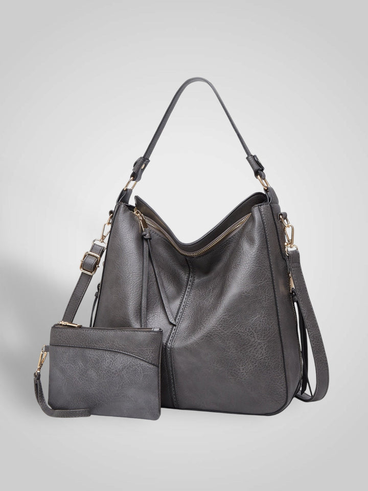Front view showing top handle, crossbody strap, top zip closure and matching pouch, grey