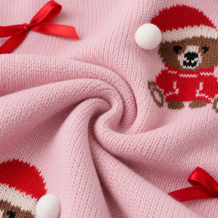 Detail of the knit surface with bear motif, pom pom and bow