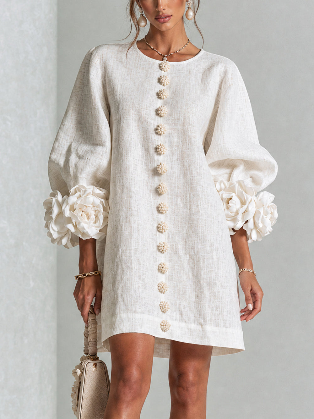 Front view of round neckline, button placket and rose-shaped cuffs, white