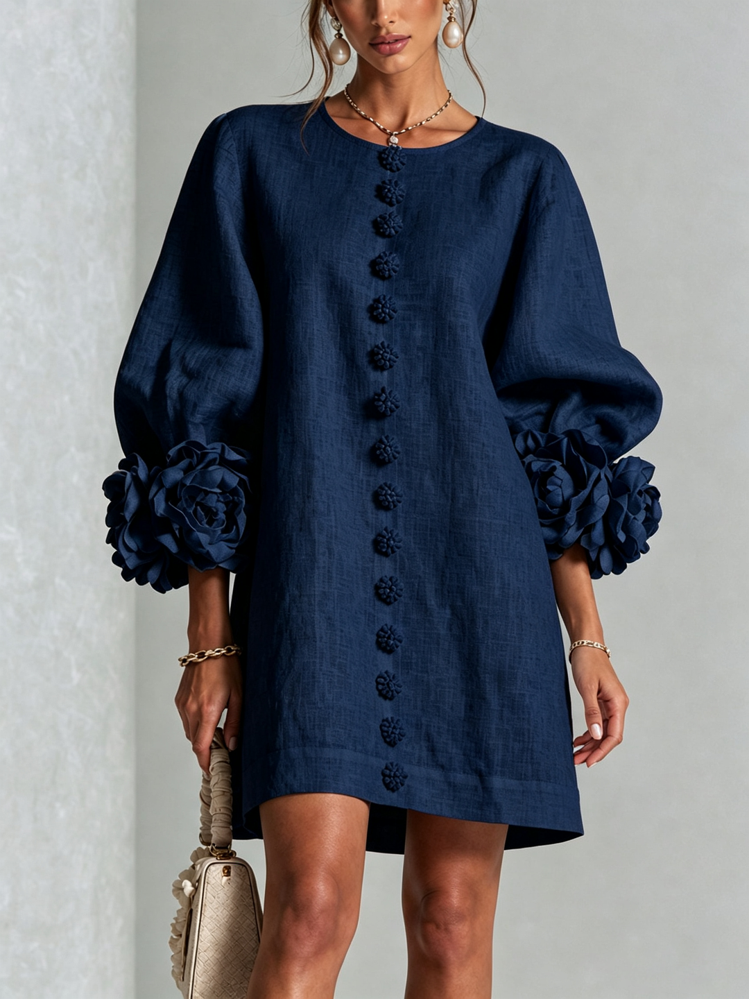 Front view of round neckline, button placket and rose-shaped cuffs, navy blue