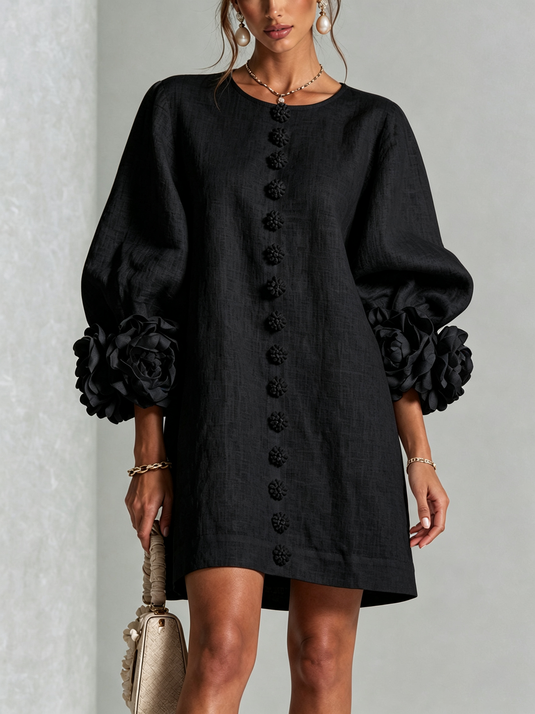 Front view of round neckline, button placket and rose-shaped cuffs, black