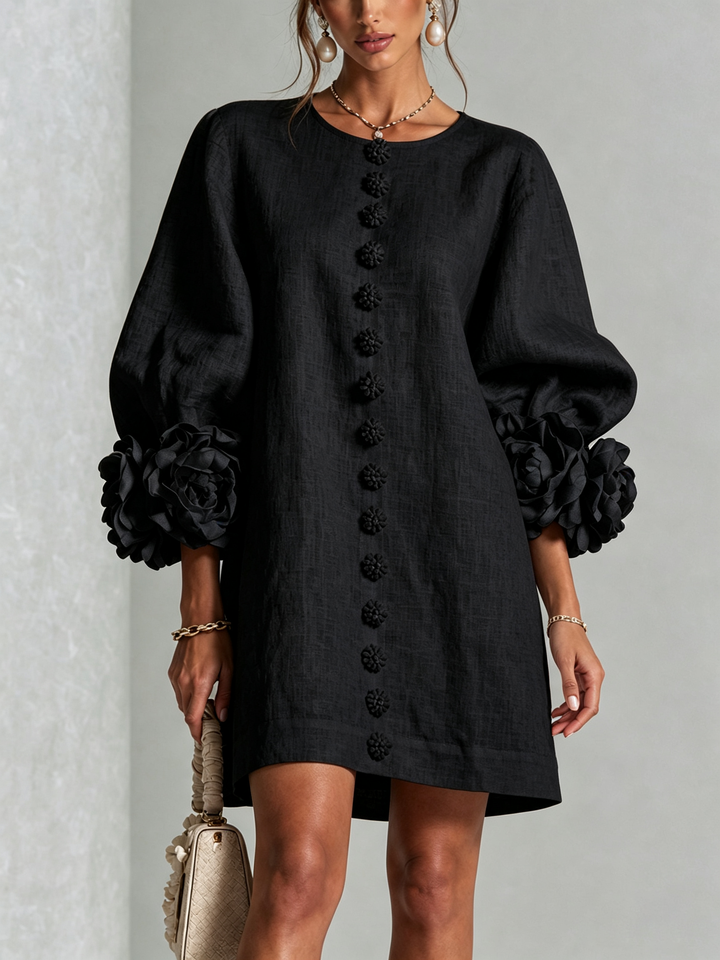Front view of round neckline, button placket and rose-shaped cuffs, black