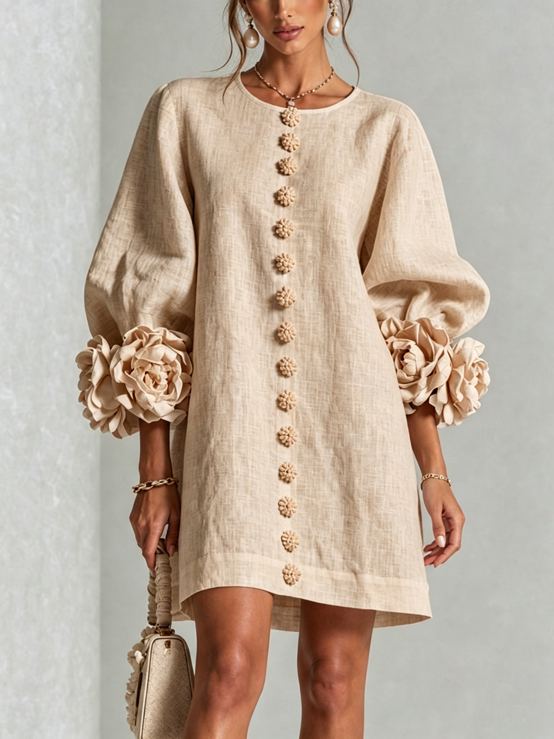 Front view of round neckline, button placket and rose-shaped cuffs, beige