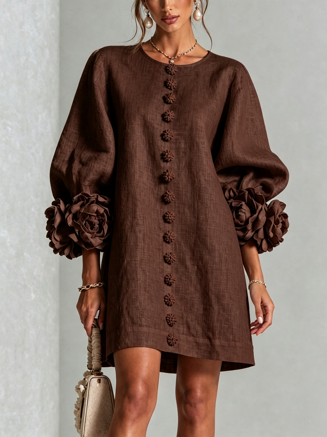 Front view of round neckline, button placket and rose-shaped cuffs, brown