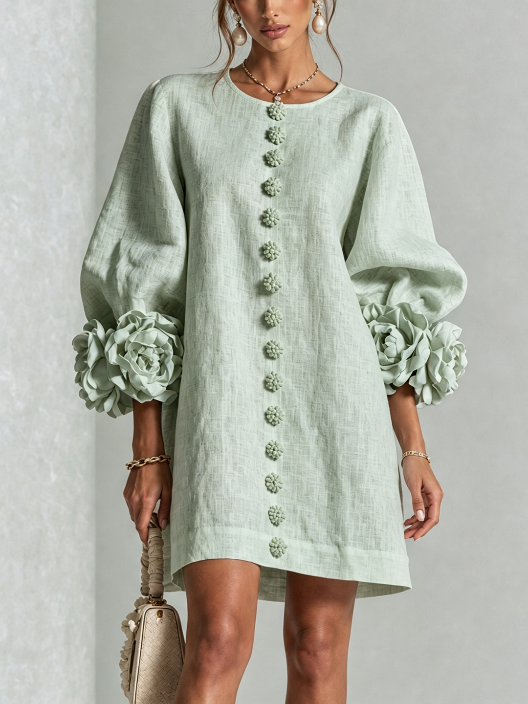Front view of round neckline, button placket and rose-shaped cuffs, sage green
