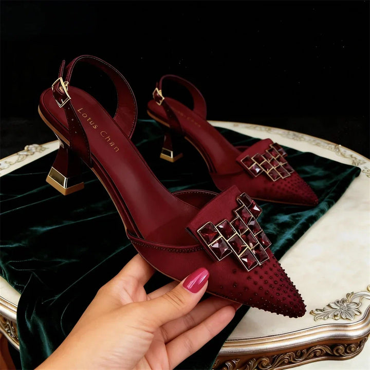 Side view of pointed toe upper with jeweled buckle plate and block heel