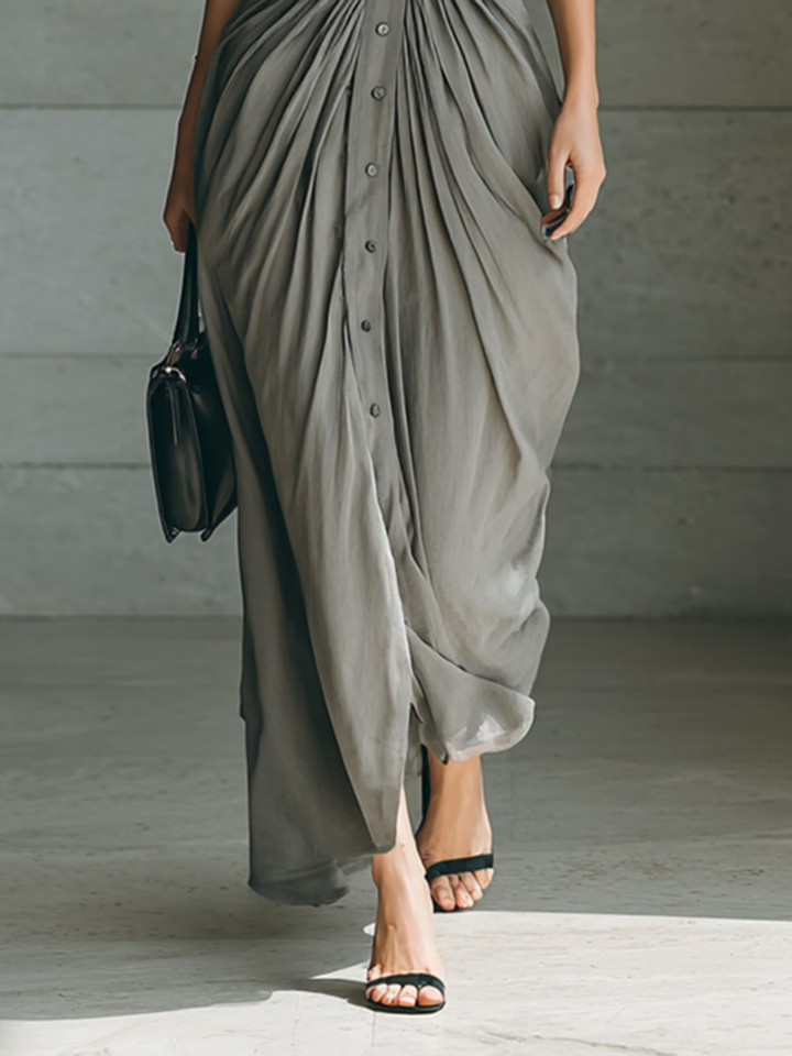 Detail view of button placket, pleated skirt and floor-length hem