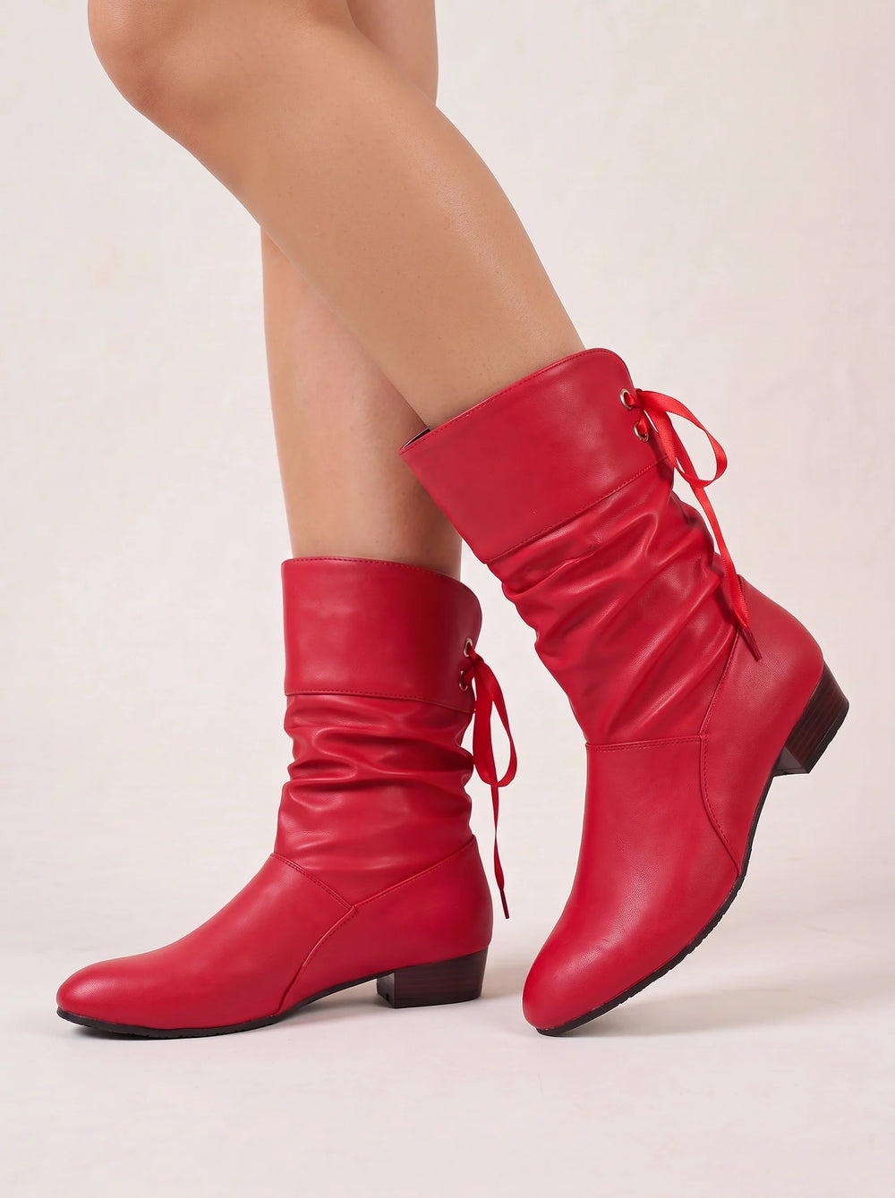 Side view showing ruched shaft, bow tie back lacing and block heel, red