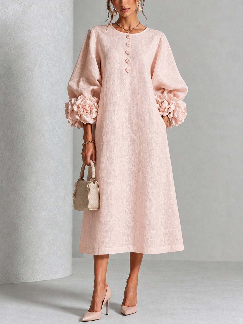 Front view showing round neckline, button placket, long sleeves and floral cuffs, pink