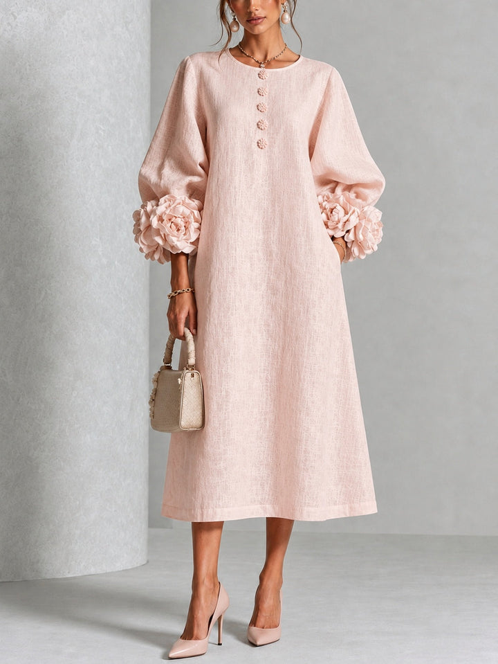 Front view showing round neckline, button placket, long sleeves and floral cuffs, pink