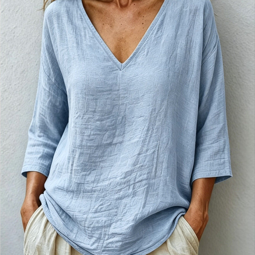 Front view showing v-neckline and curved shirttail hem, blue