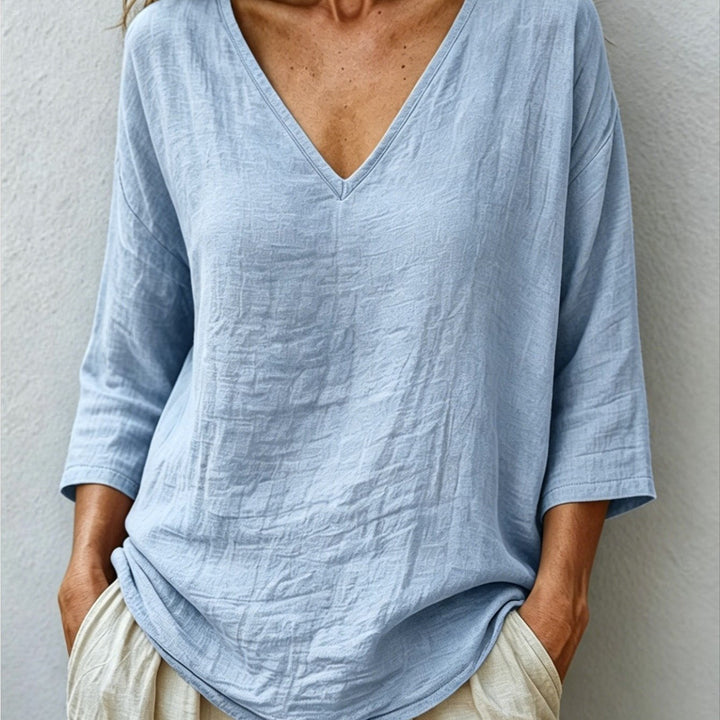 Front view showing v-neckline and curved shirttail hem, blue