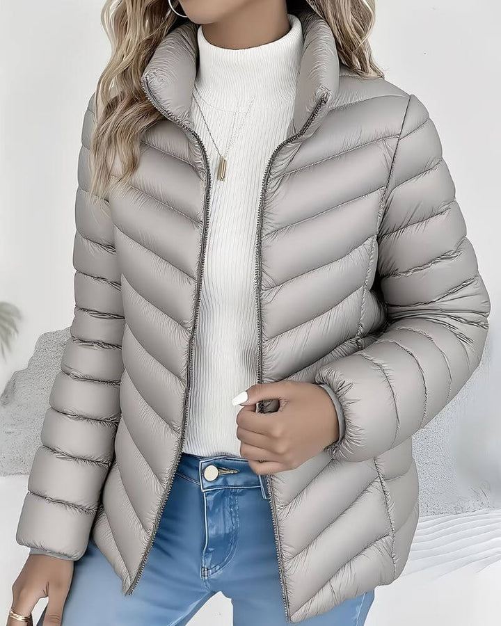 Side view showing stand collar, long sleeves and quilting, grey