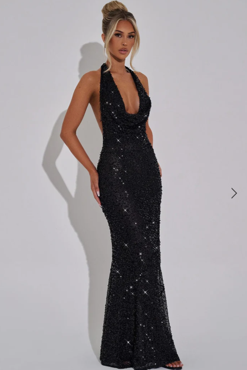 Side view of halter neckline and flared sequin skirt, black