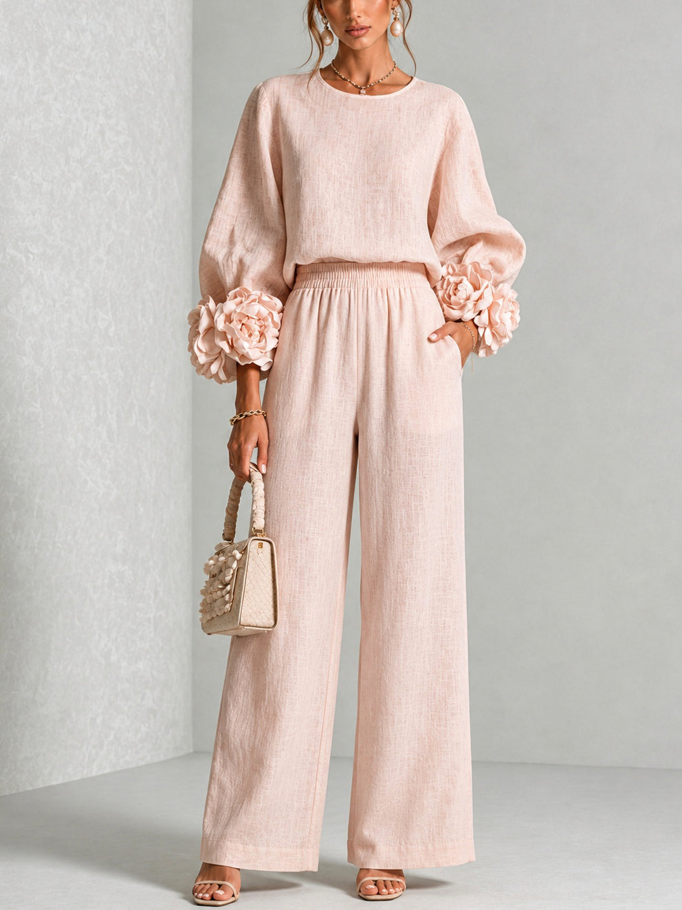 Front view of round neckline, long sleeves with floral cuffs, banded waist and wide legs, blush pink