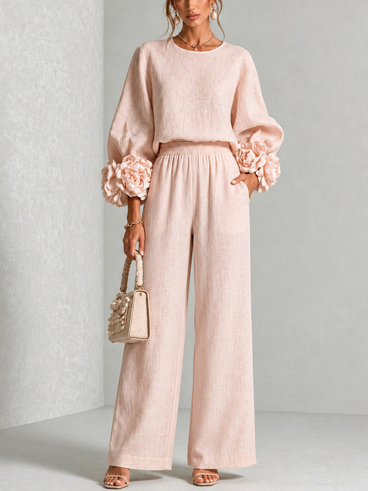 Front view of round neckline, long sleeves with floral cuffs, banded waist and wide legs, blush pink