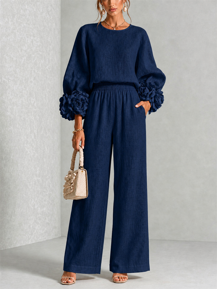 Front view of round neckline, floral cuffs, side pocket and wide legs, dark navy