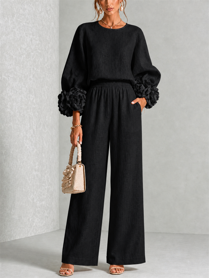 Front view of round neckline, floral cuffs and wide legs, black