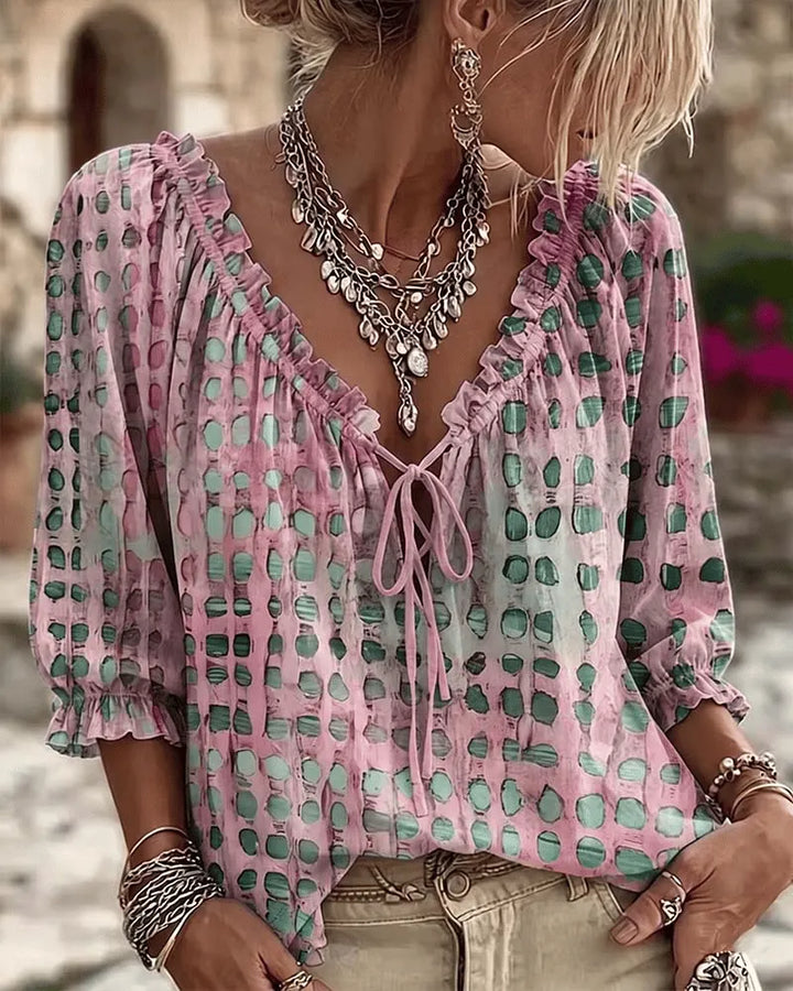 Front view of v-neckline with tie and ruffle trim, three-quarter puff sleeves, pink