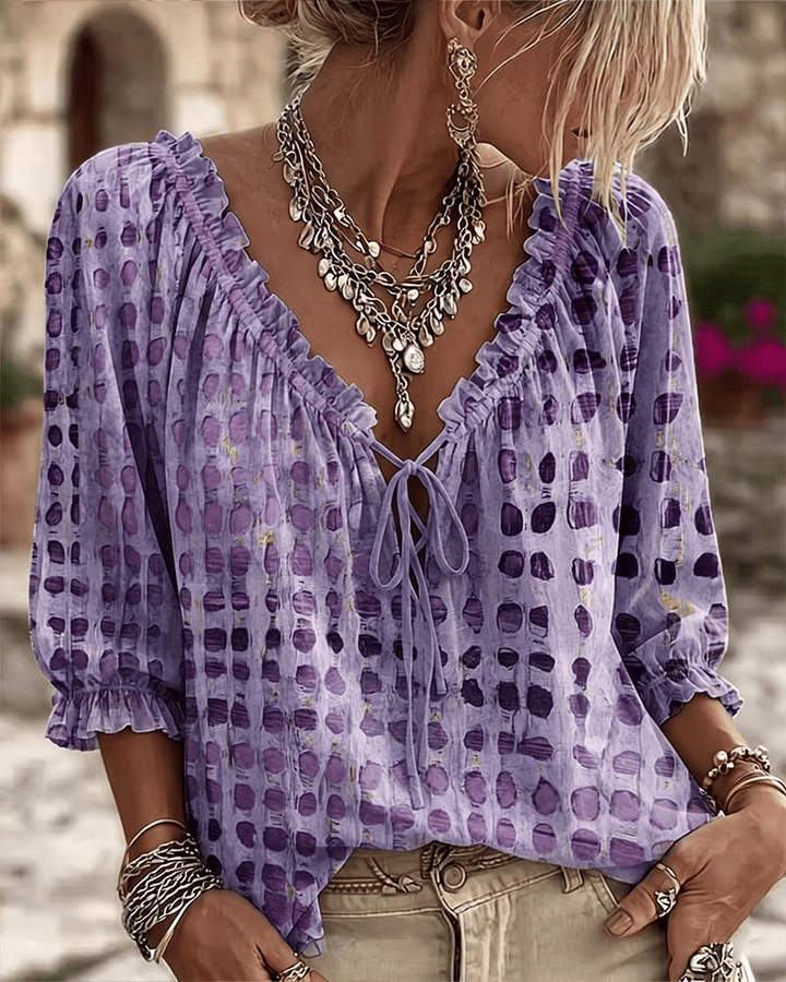 Front view of v-neckline with ruffle trim, tie fastening and puff sleeves, purple