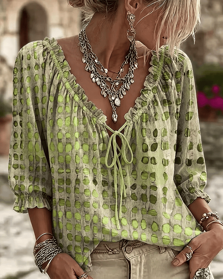 Front view of v-neckline with tie fastening, ruffle trim and puff sleeves, green