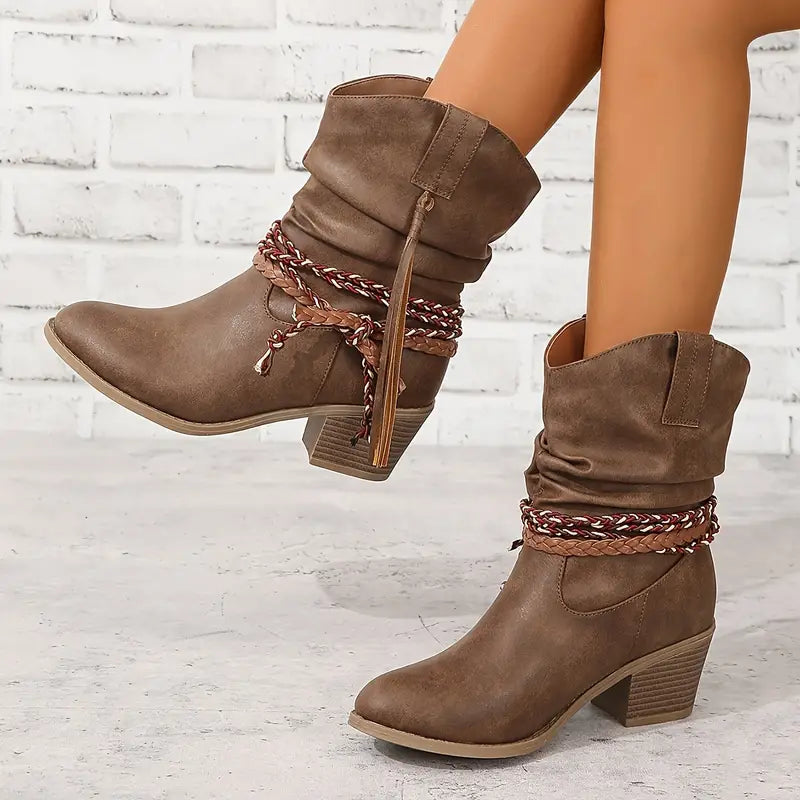 Side view of ankle boot with braided wraps, tassels, block heel and pointed toe, brown