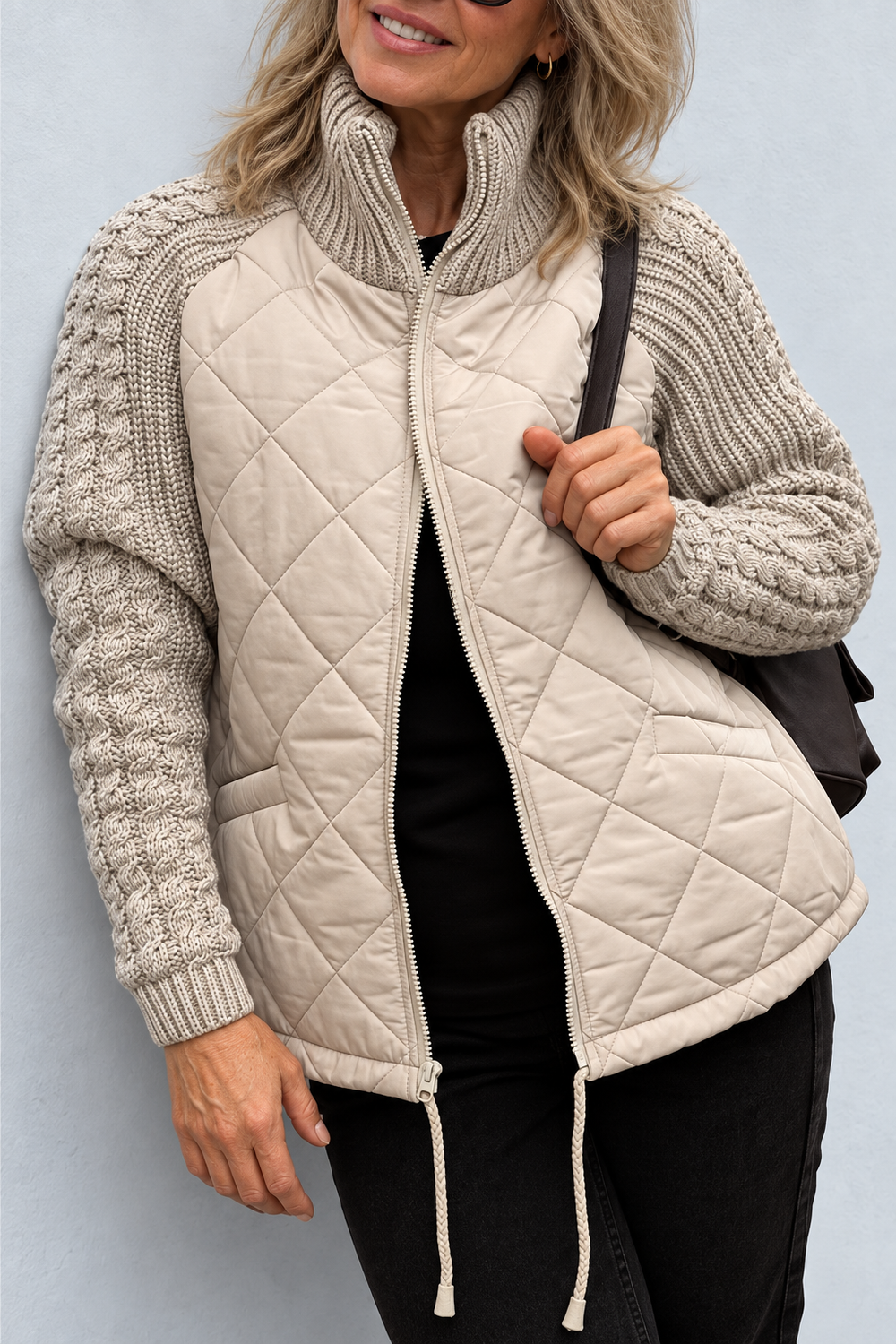 Front view showing stand collar, cable-pattern sleeves, quilted body, front zip and drawstring hem, khaki