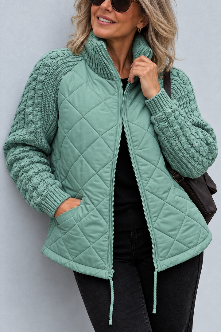 Front view showing stand collar, cable sleeves, quilted body with side pocket and front zip, aqua sage