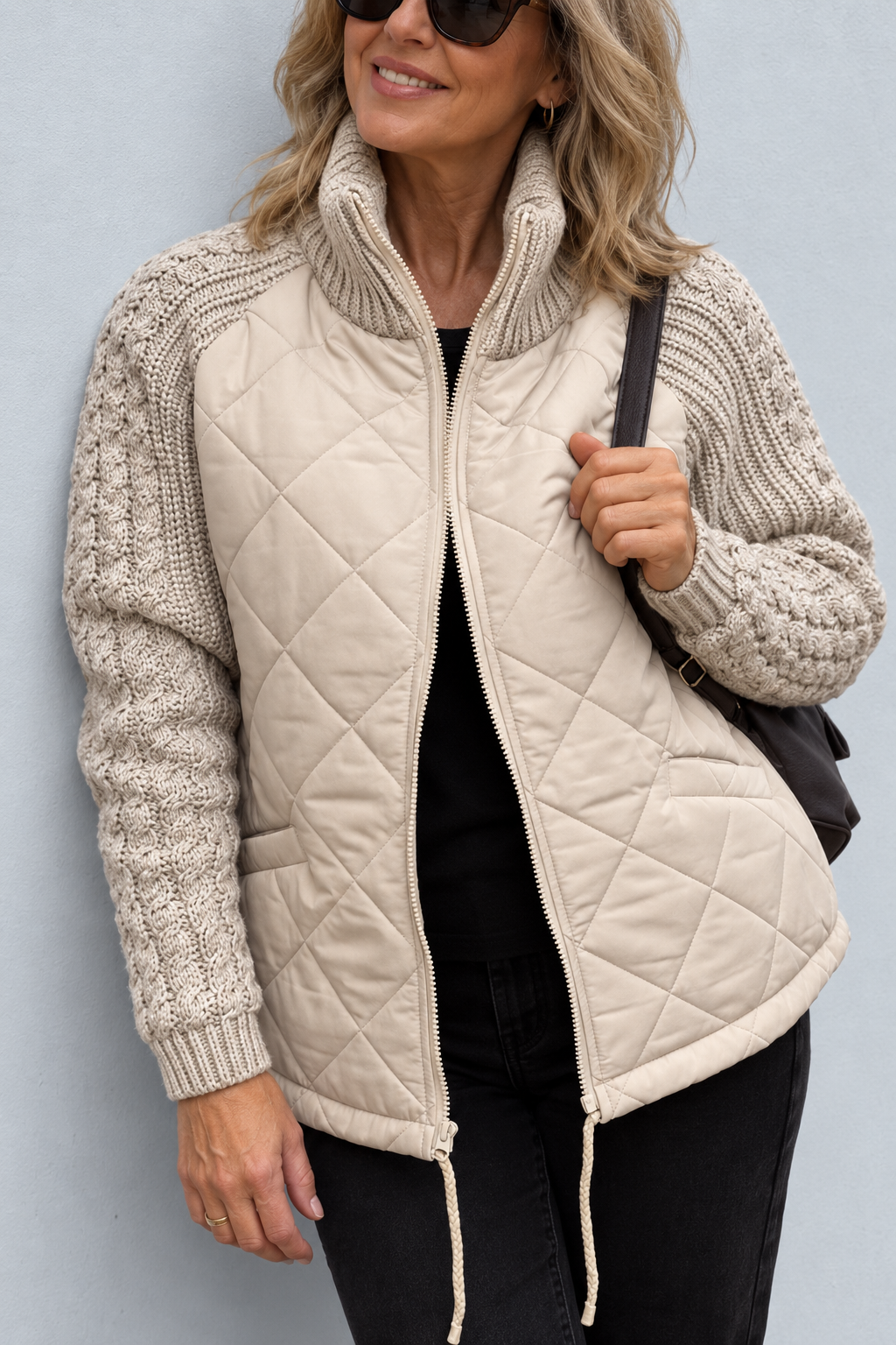 Front view showing stand collar, quilted body, side pocket and drawstring hem with toggles