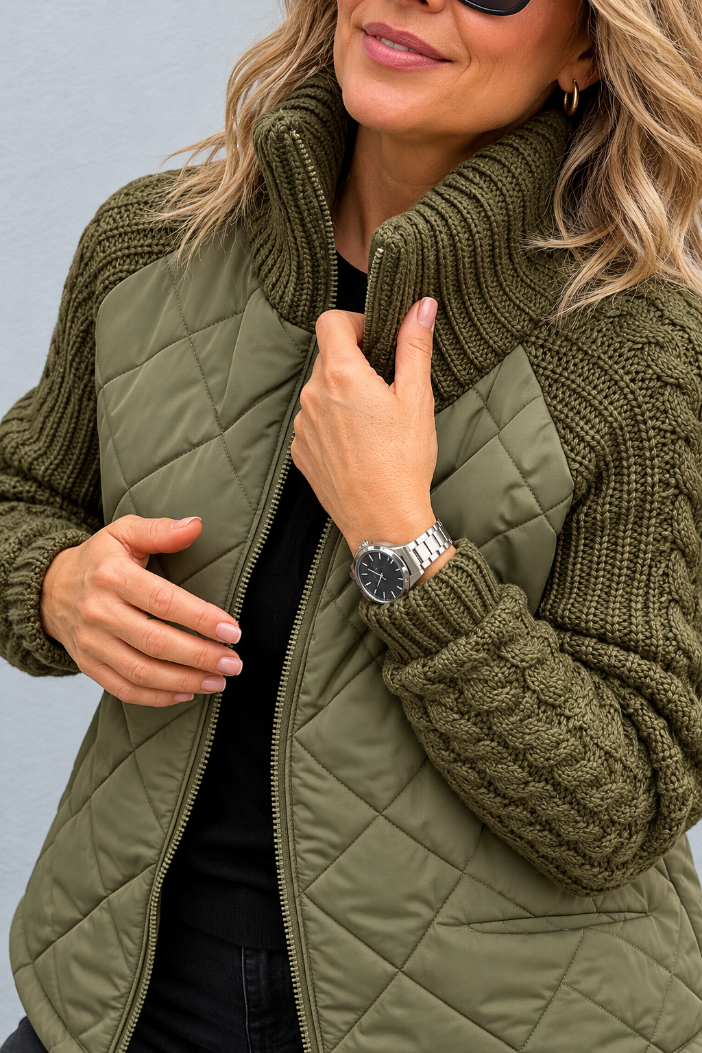 Detail view of stand collar, cable sleeve with banded cuff, quilted body and front zip